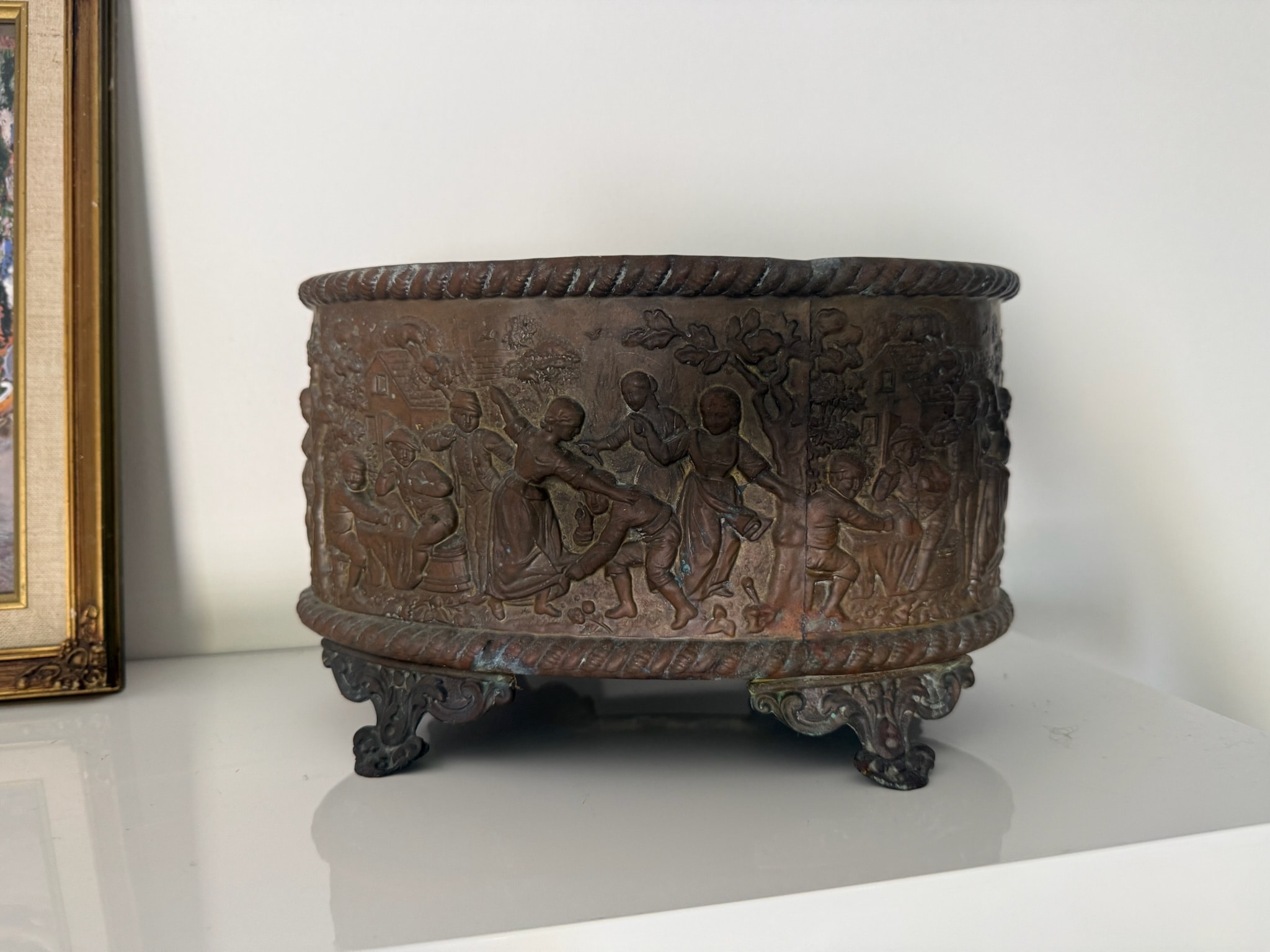 Ornate bronze vessel with cherub relief carvings