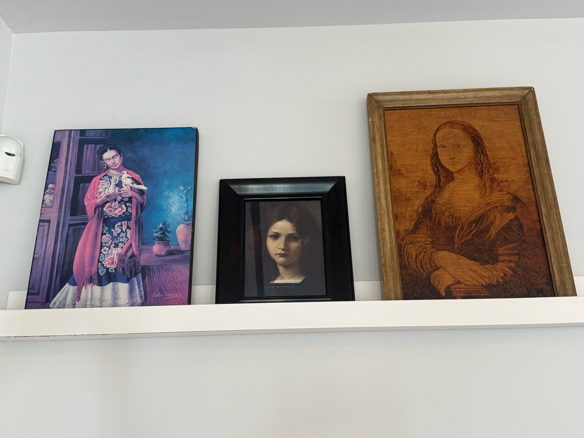Framed portrait paintings displayed on shelf